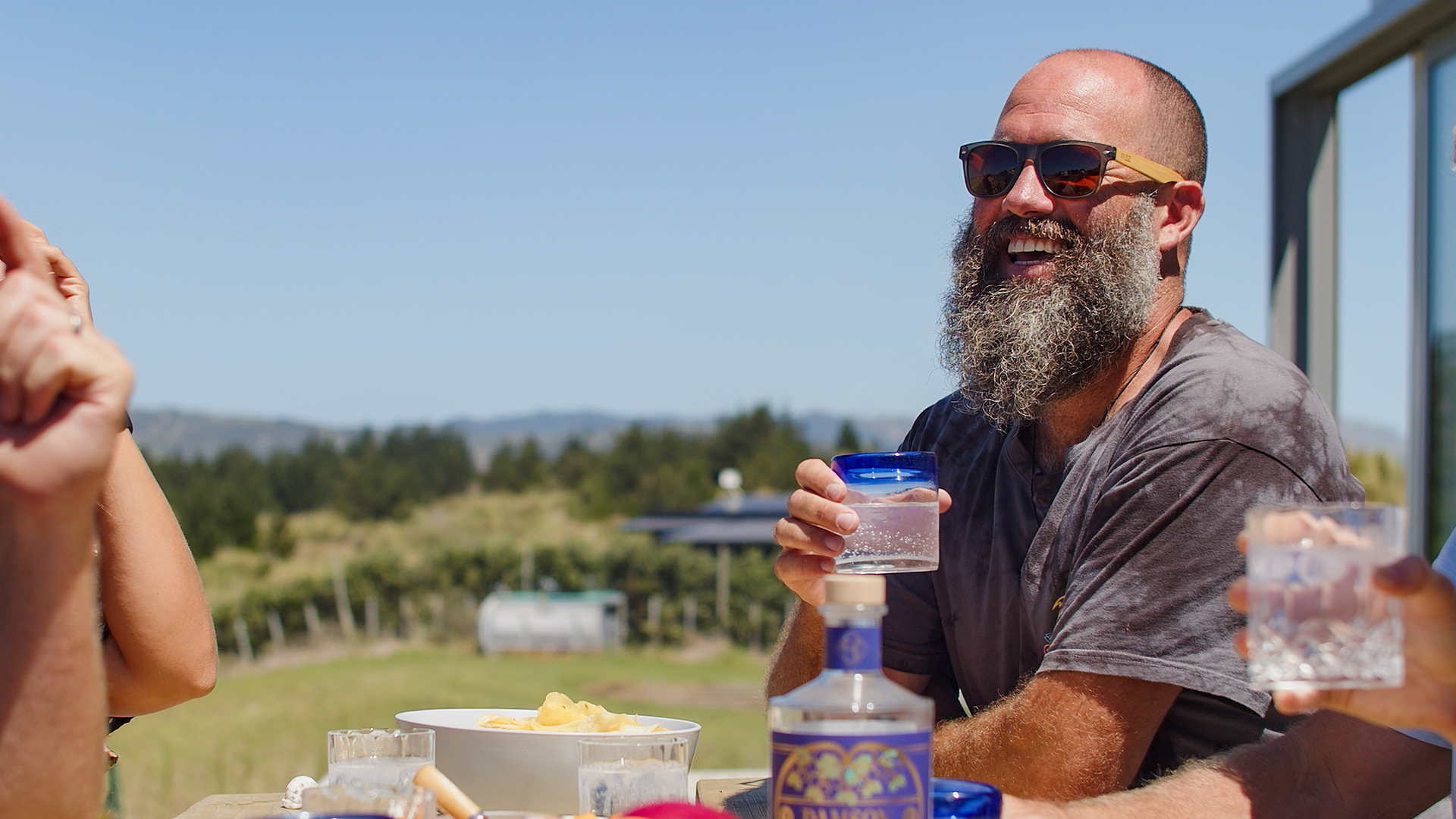 Holding Glass Of Damson Plum Gin outdoors laughing